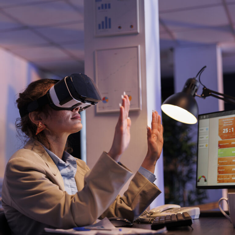 Corporate employee planning financial investment strategy usinh hologram, to increase company profit. Businesswoman wearing virtual reality headset, working late at night in startup office